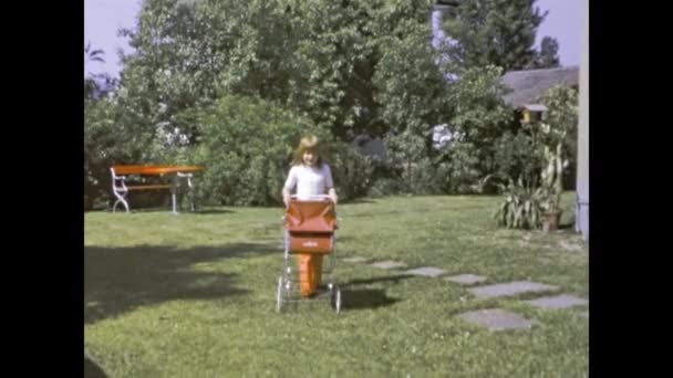 Suhr Swiss Mai 1971 小さな女の子とおもちゃのベビーカーシーンで70年代 — ストック動画