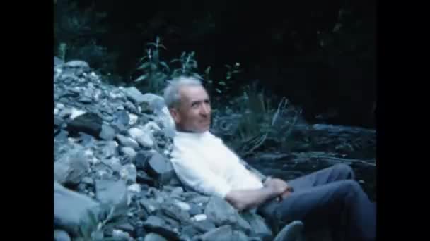 Dolomites Italy June 1970 Man Relaxing River Bank Scene 70S — Vídeo de stock