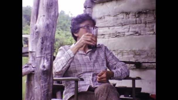 美国安纳波利斯可能是1966年 60年代的老妇人坐在房子的门廊上喝酒 — 图库视频影像