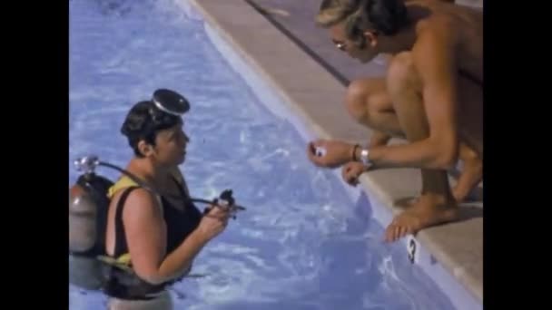 アメリカ合衆国マイアミ1975年6月 リゾート地の観光客は70年代のプールシーンでダイビングを試してみてください ダイビングスクールシーン — ストック動画