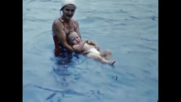 1947年6月 美国圣地亚哥 40多岁的妈妈带着孩子在游泳池里玩耍 — 图库视频影像