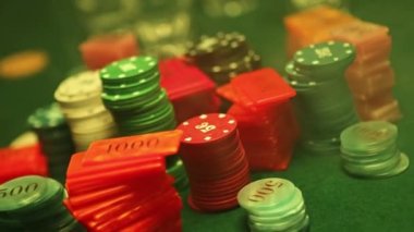 Poker chips are stacked on a green textured table smoke of cigars fills the room