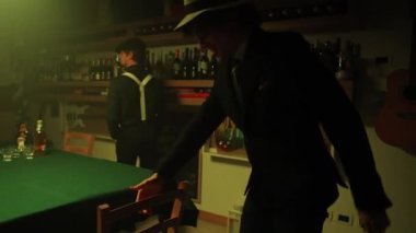 Group of mobsters arrive at the bar and sits at the poker table with a briefcase