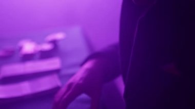 Young man carefully prepares to gamble with neatly sorted money in dim lit room