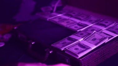 Hands of man place stacks of US dollars into briefcase preparing for poker game