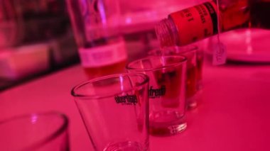 New York, United States 17 January 2023: Whiskey is being poured into shot glasses in a bar, suggesting a nightlife scene where gambling and alcohol are part of the atmosphere. Carefree and indulgent atmosphere focused on enjoyment.