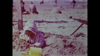 Rimini, Italy june 1975: A nostalgic trip down memory lane with this historical video capturing children on the beach during their summer vacation in the 70s.