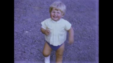 Rimini, İtalya Haziran 1975: Çocukların oynadığı bir aile sahnesinin yer aldığı 70 'lerden kalma nostaljik bir videoyla anılara bir gezi yapın. Çocukluğunun anılarını tekrar yaşa.