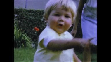Rimini, Italy june 1975: Take a trip down memory lane with this nostalgic video from the 70s, featuring a family scene with children playing. Relive the moments of your own childhood