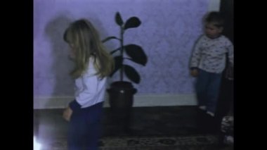 Rimini, Italy june 1975: Bring back old memories with this vintage video of children excitedly opening Christmas gifts in their home in the 70s