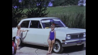 Rimini, Italy june 1975: A nostalgic look back at children playing and having fun among cars in the 70s.