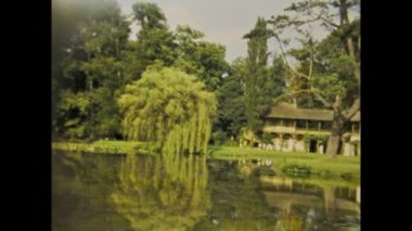 Copenhagen, Denmark may 1968: A historical video that captures a beautiful Danish house surrounded by a lush garden and a serene pond, set in the 60s.