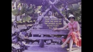 Miami, United States june 1979: A cheerful woman sits on a park bench and enjoys the sunny day in this historic footage from the 70s