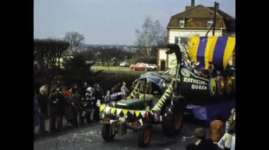 Berlin, Germany march 1975: A historical video of a bustling street carnival parade featuring vibrant and elaborate themed floats from the 1970s