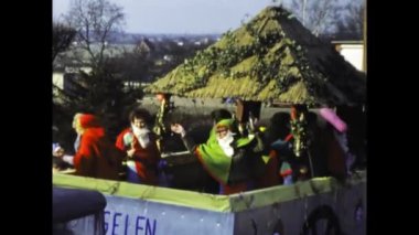 Berlin, Germany march 1975: A historical video of a bustling street carnival parade featuring vibrant and elaborate themed floats from the 1970s