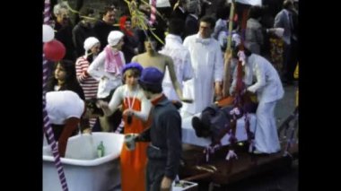 Berlin, Germany march 1975: A historical video of a bustling street carnival parade featuring vibrant and elaborate themed floats from the 1970s