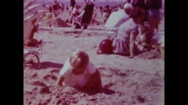 Rimini, Italy june 1975: A nostalgic trip down memory lane with this historical video capturing children on the beach during their summer vacation in the 70s.