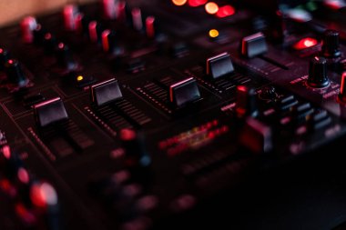 Close-up of an audio mixer with knobs and buttons, perfect for music production and audio engineering projects