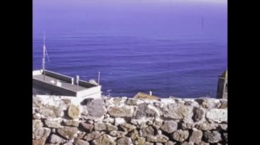 ALGHERO, İtalya 8 Haziran 1974: 1970 'lerde Alghero kıyılarının nefes kesici bir görüntüsü. Turkuaz suların doğal güzelliğinin ve bu çarpıcı İtalyan varış yerinin engebeli uçurumlarının tadını çıkarın.