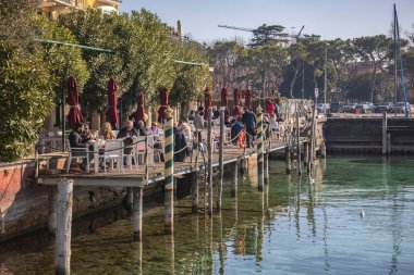 Sirmione, Italy 15 February 2023: The beautiful landscape of Sirmione on the Garda Lake Riviera, with its crystal clear waters and stunning mountains in the distance.