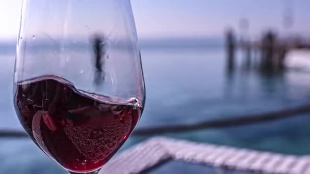 酒杯放在海滨酒吧桌旁的酒杯上的酒杯 可以看到里维埃拉河 — 图库视频影像