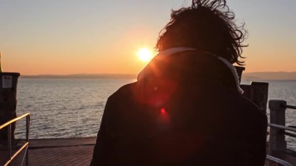 一个背对着他的小男孩 凝视着日落 凝视着平静的湖面 — 图库视频影像