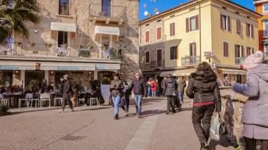 Sirmione, Italy 16 February 2023: Charming historic center of Sirmione, a popular tourist destination on Lake Garda in Italy, bustling with visitors exploring its narrow streets and ancient buildings.