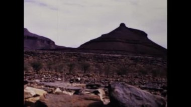 Dakar, Senegal Haziran 1975: Tarif: Afrika çölünün nefes kesici güzelliğini bu görüntülerdeki turistlerin gözlerinden deneyimleyin. Sonsuz kum tepelerine, antik kaya oluşumlarına tanık olun.