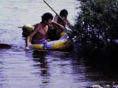 Floransa, İtalya Haziran 1975: Nehirde şişme bir sala binerken gülen ve su sıçratan bir grup çocuk.