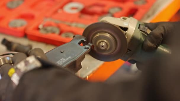 金属を粉砕する角度研削盤を操作する機械的手のクローズアップ映像 — ストック動画