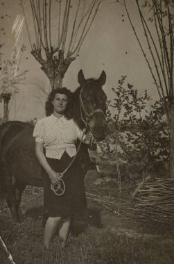 Roma, İtalya 1941: 1940 'ların kırsal kesiminde görkemli atının yanında duran, zamansız zarafet saçan bir kadının klasik esinlenilmiş portresi.