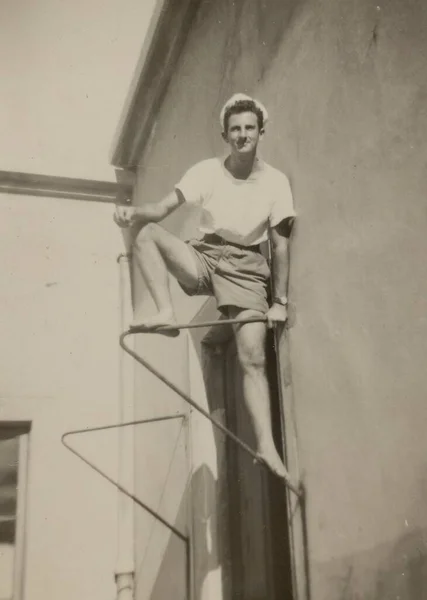 1941年 昭和16年 5月イタリア ローマ壁にしがみつく若い男の印象的な肖像画 1940年代の若き反逆の精神を想起させる — ストック写真