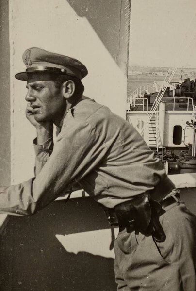 Rome, Italy may 1951: Vintage Italian soldier in fatigue uniform leaning exhausted against a wall. Nostalgic military concept.