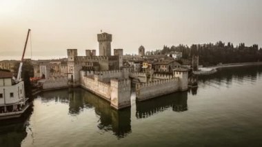 Güneş batarken yukarıdan Sirmione Kalesi 'nin güzelliğine tanık olun. Bu nefes kesici hava görüntülerinde.