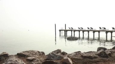 Huzurlu ve atmosferik bir manzara. Sakin bir göle doğru uzanan sisli bir iskele. Huzurlu yalnızlık hissi uyandırıyor.