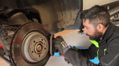 Milan, İtalya 11 Nisan 2023: Yetenekli tamirci, arabanın fren pedlerini ustalıkla hassasiyet ve özenle değiştirdi.