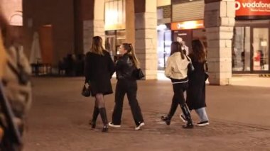 Ferrara, İtalya, 11 Nisan 2023: Bir grup genç gece yarısı sokaklarda yürüyüp sohbet ediyor ve birbirlerinin arkadaşlığından keyif alıyorlar..