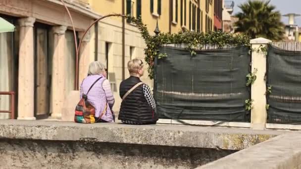 Sirmione Italia Abril 2023 Dos Mujeres Mayores Relajan Una Pared — Vídeos de Stock