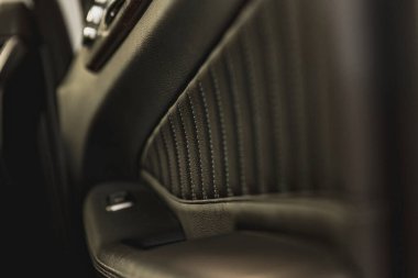 Deri döşemeli ve görünür dikişli bir arabanın iç kapısının panelini kapat..