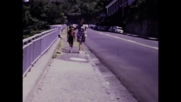 イタリア パレルモ1968年7月 1960年代の歩道をゆっくりと歩く母親と彼女の子供の魅力的なヴィンテージ映像 — ストック動画