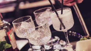 Yetenekli bir barmenin özenle ve titizlikle nefis kokteyller hazırlamasını izleyin..