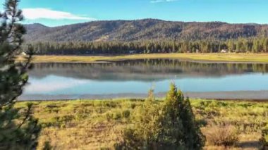Güzel bir gün batımında sakin bir dağ gölünün çarpıcı hava manzarası..