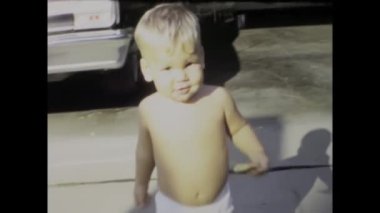 City Lake, Amerika Birleşik Devletleri Haziran 1969: Bir çocuğun ilk adımlarının ve yürüyüşlerinin iç açıcı görüntüleri, 60 'ların klasik Amerikan aile videosunda çekildi.