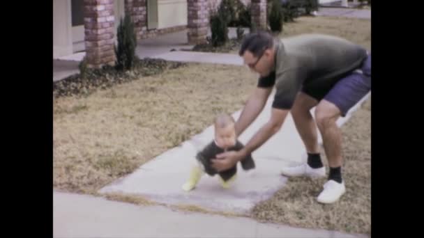1969年6月 美国城市湖 1960年代 一位蹒跚学步的幼儿踏上典型的美国家庭第一步的温馨的家庭视频 — 图库视频影像