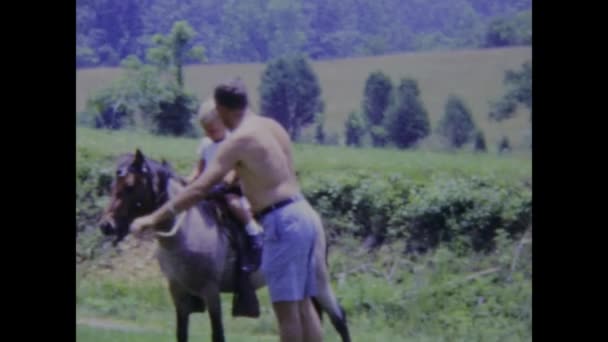 1969年6月 美国城市湖 一个父亲和他的孩子们在美丽的农场里分享他骑马的激情的怀旧镜头 — 图库视频影像
