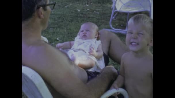 1969年6月 美国城市湖 电影中的温馨家庭时刻 20世纪60年代 父亲在一个经典的美国后院抱着孩子 — 图库视频影像