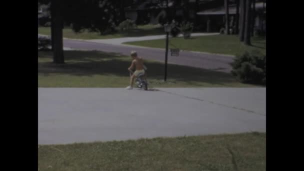 1969年6月 美国城市湖 20世纪60年代 当孩子们骑着自行车在美国家庭的一条经典车道上行驶时 怀旧地看待家庭记忆 — 图库视频影像