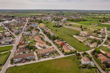İtalya 'daki yemyeşil Po Vadisi tarım arazilerinin arasına yerleşmiş tuhaf bir köyün büyüleyici hava perspektifi.