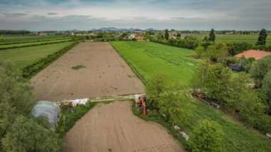 İtalya 'nın verimli Po Vadisi kırsalının canlı, yeşil manzaralarını gösteren nefes kesici bir hava videosu.