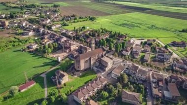 Çiçekli, yeşil Po Vadisi kırsalında, bahar günbatımında yuva yapmış tuhaf bir köyün büyüleyici hava görüntüleri..